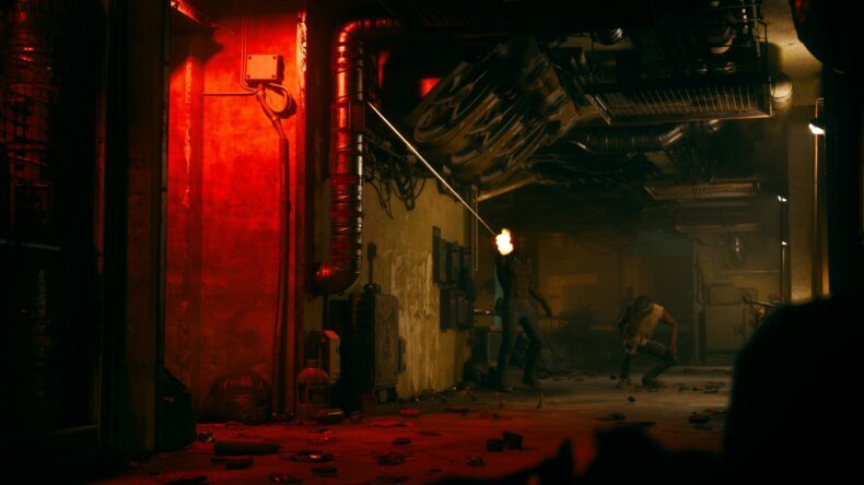 Um personagem de 'Cyberpunk 2077' disparando uma arma em um corredor industrial pouco iluminado, com luz vermelha.